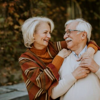 Handsome senior couple embracing in autumn park